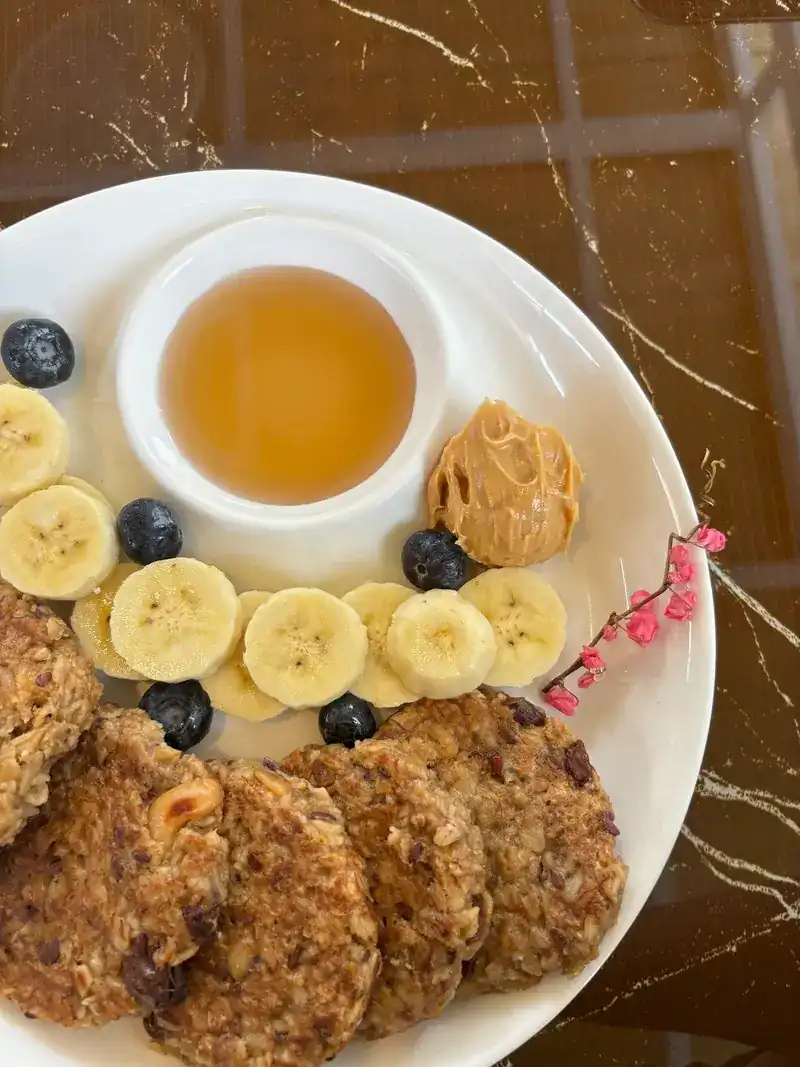 Oat pancakes with banana, blueberries, peanut butter and a pot of honey