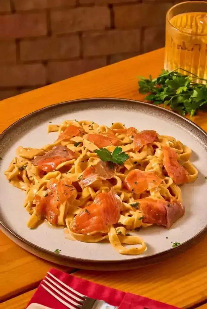 Ribbon pasta with salmon on a speckled plate
