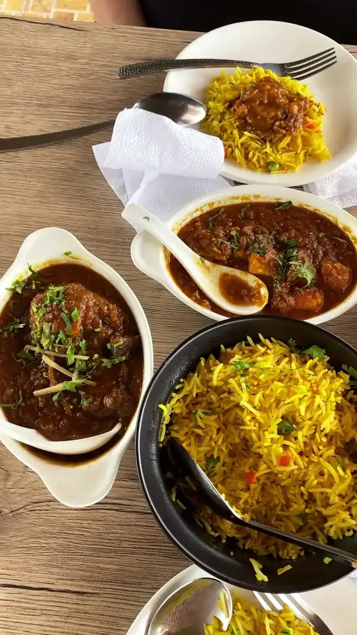 Two curries and a bowl of yellow rice, seen from above