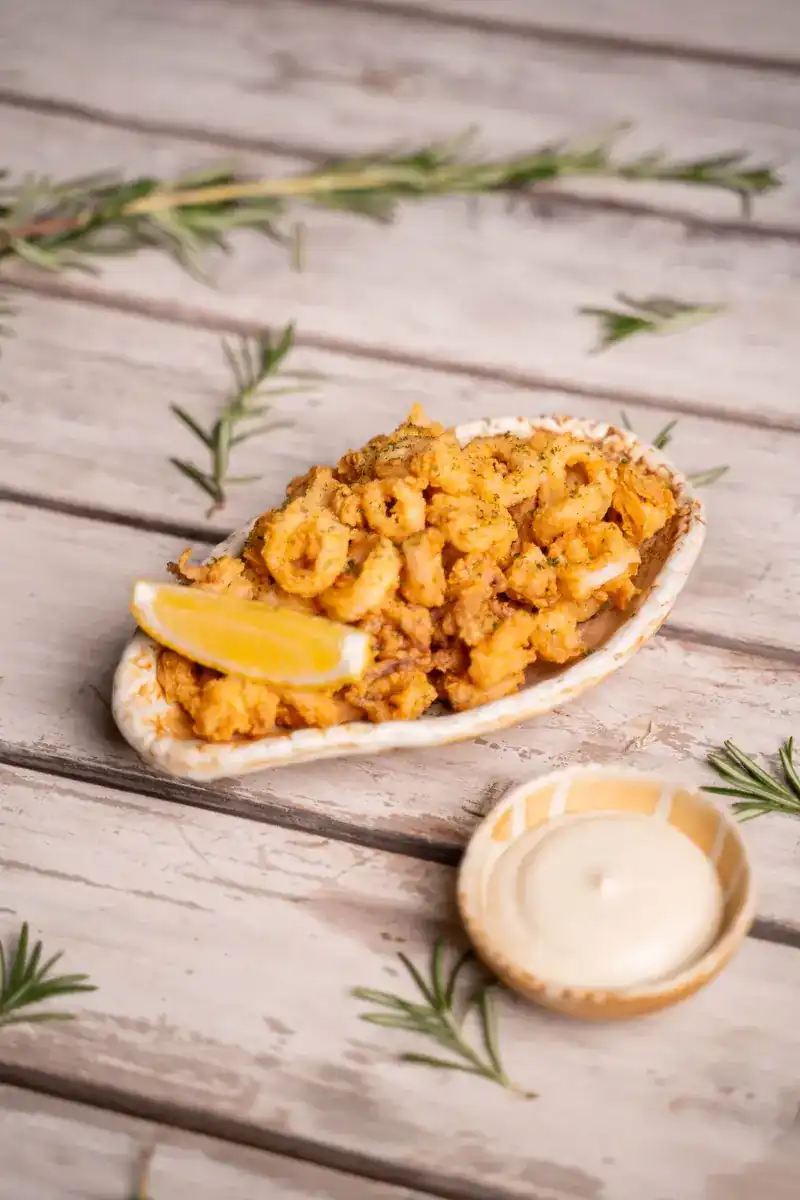 Crispy calamari with a lemon wedge and aioli