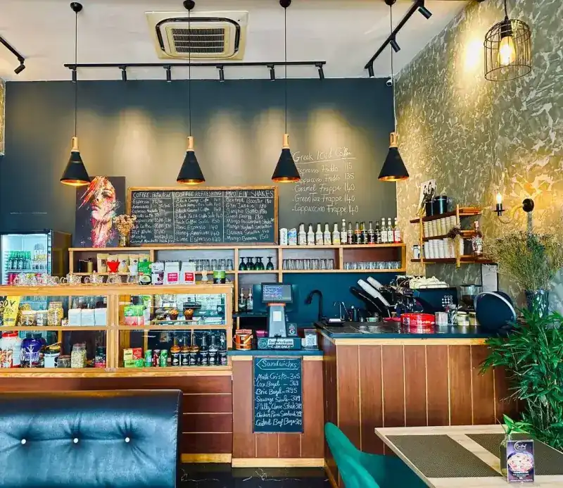 Inside: chalkboard menus on a dark wall, black pendant lamps and the wooden counter