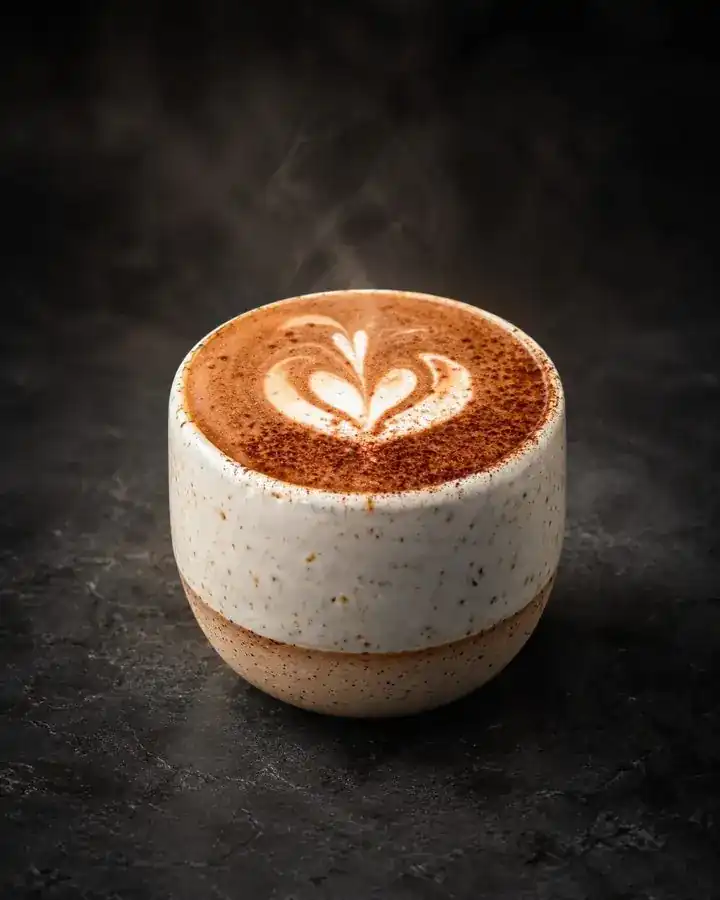 Mocha with cocoa dusting in a speckled cup