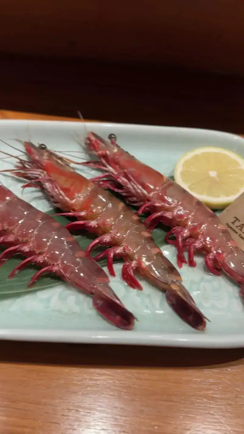 Three raw prawns with a slice of lemon