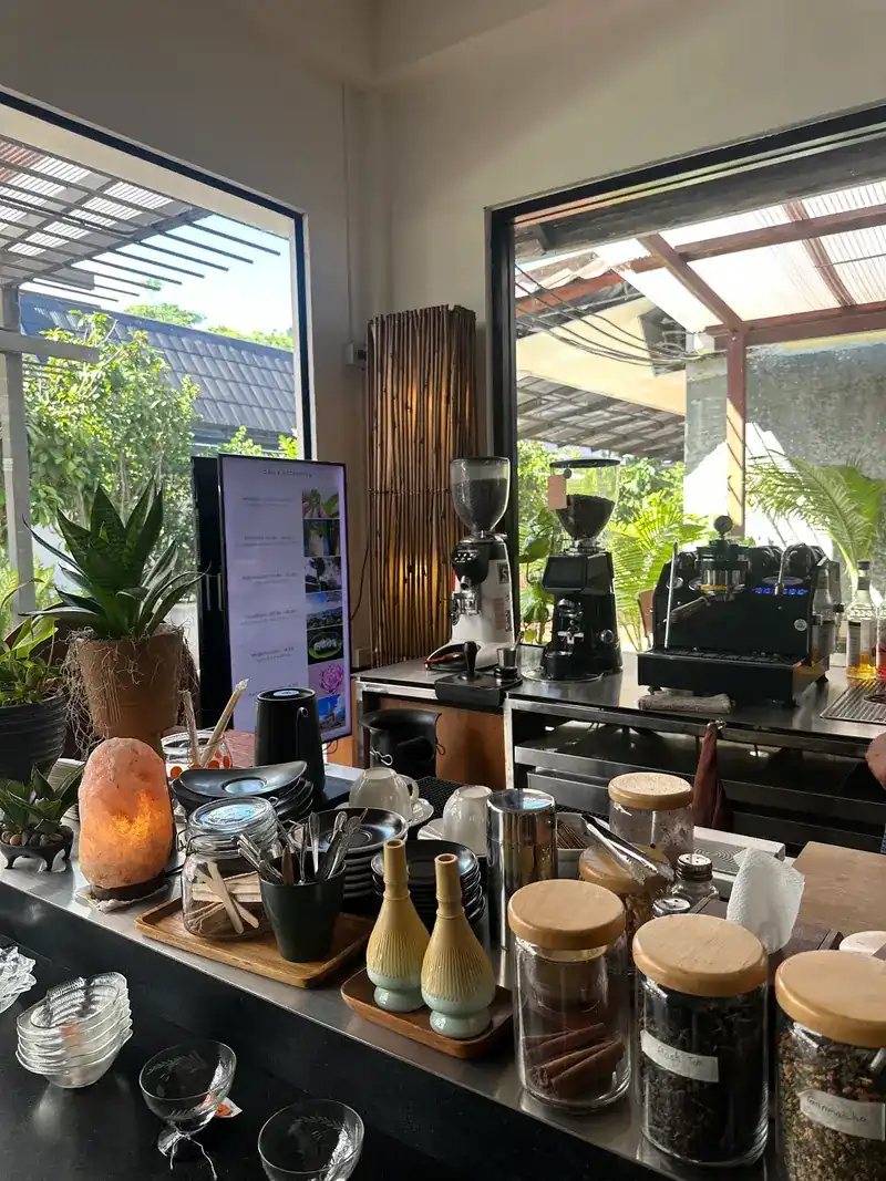 The coffee counter by the window, with grinders, an espresso machine, a salt lamp and glass jars