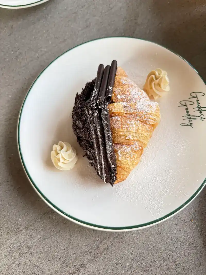 A croissant half coated in chocolate with cream / ครัวซองต์เคลือบช็อกโกแลตครึ่งชิ้นกับครีม