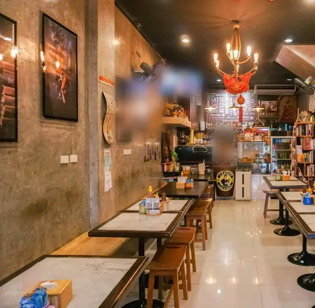 Inside I-Kroon Cafe: marble-topped tables, wooden stools and a chandelier over the counter
