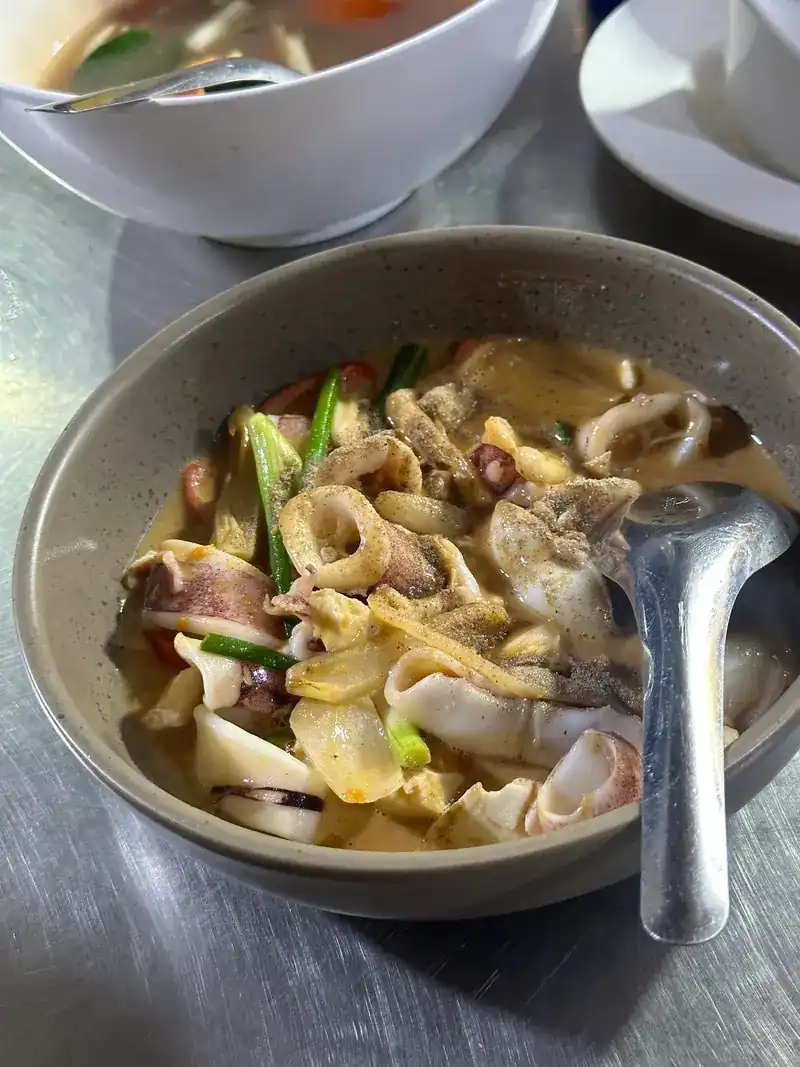 Squid soup in a grey bowl with a spoon