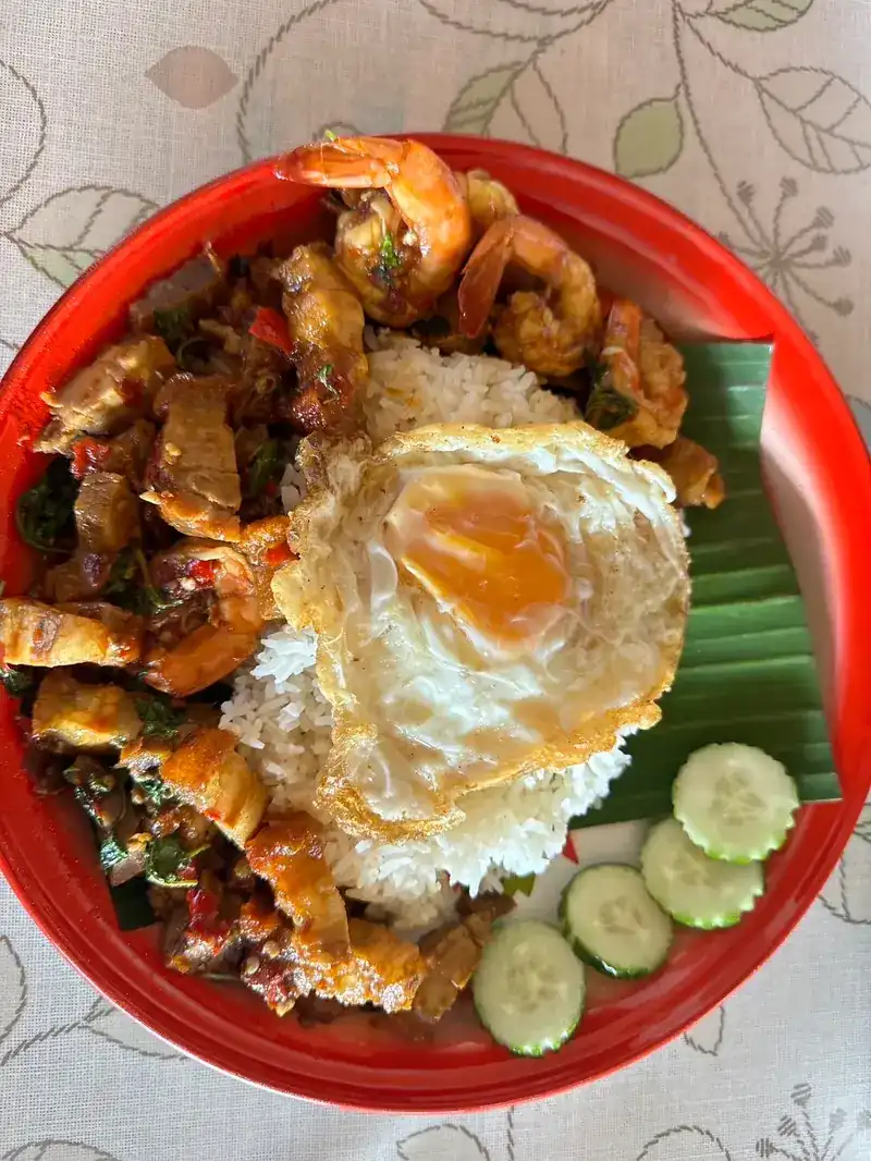 Pork and shrimp stir-fried with chilli, on rice with a fried egg and cucumber