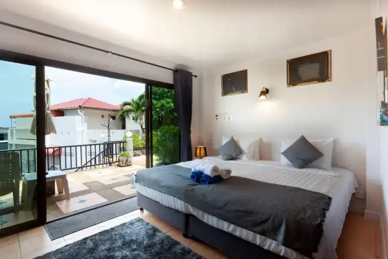 A room at Two Chefs Inn with a large bed and sliding doors open to a tiled terrace
