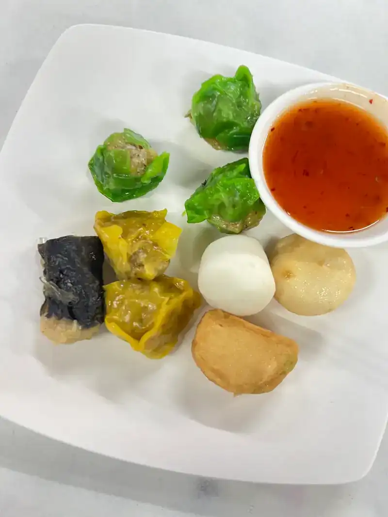 A plate of dim sum with a chilli dip