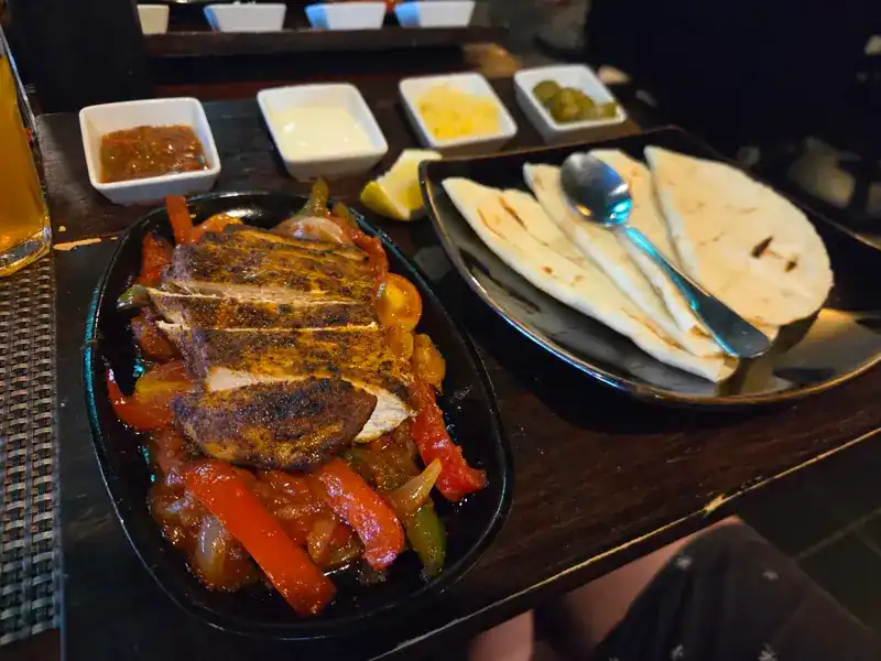 Sizzling chicken with peppers and onions, with tortillas on the side