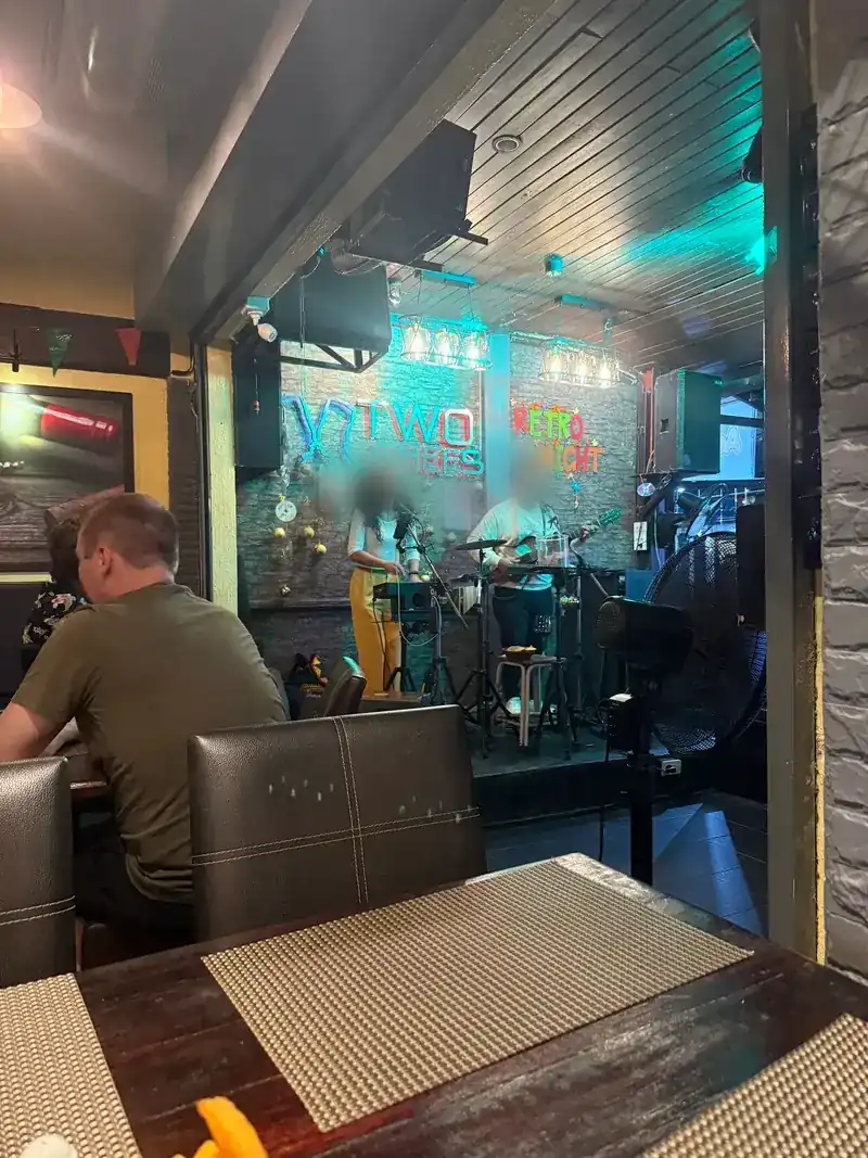 A duo playing live on the small stage under the Two Chefs sign