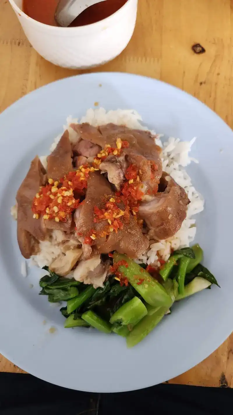 Pork leg rice topped with chopped red chilli, with greens