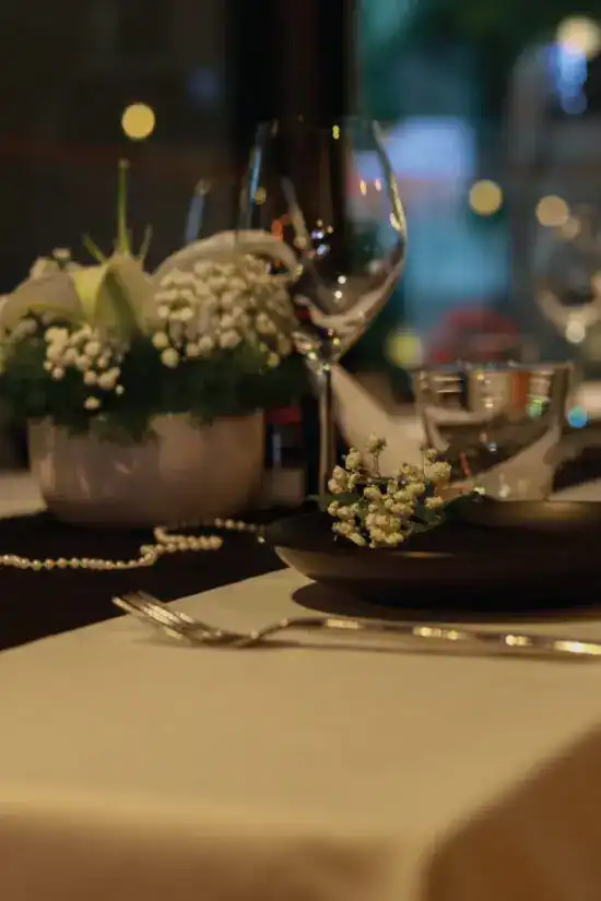 A table laid for dinner with white flowers and a wine glass