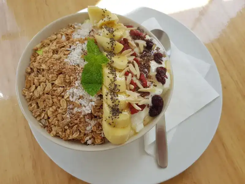 Granola bowl with banana, almonds, cranberries, coconut and chia seeds