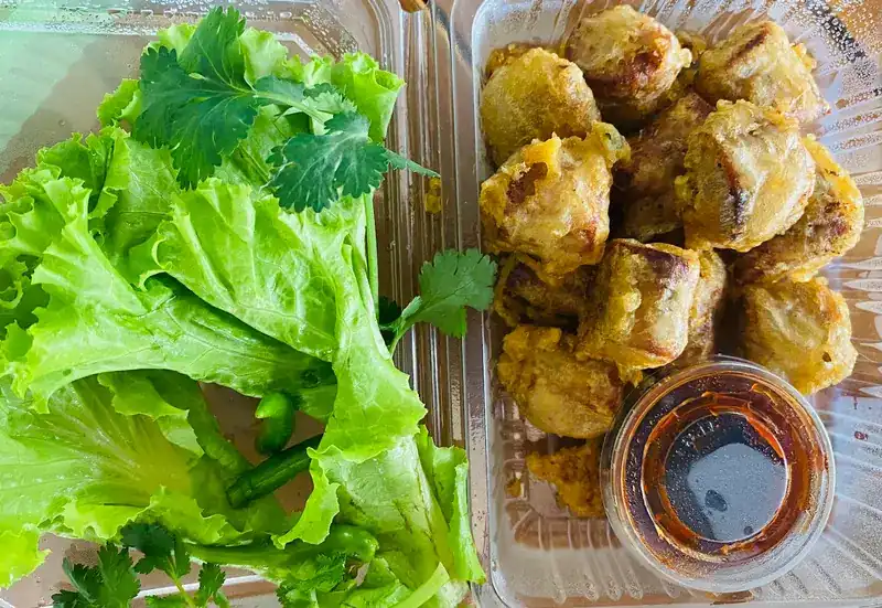 Fried kian to take away: sliced and boxed with lettuce, coriander, green chilli and a cup of sauce