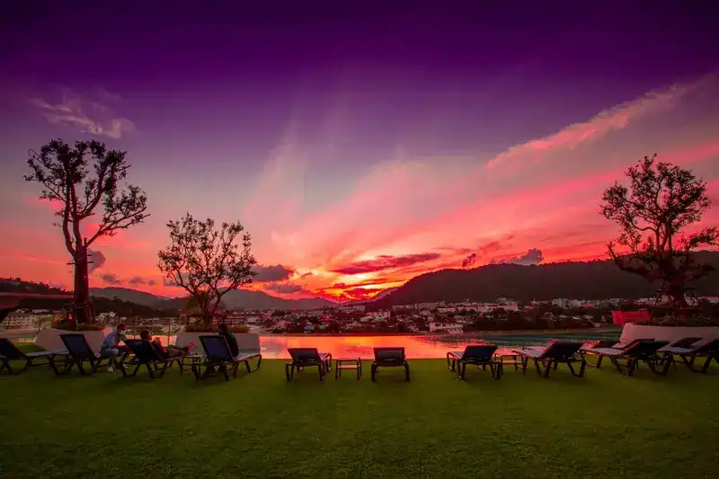 The rooftop lawn and loungers under a purple and pink sunset