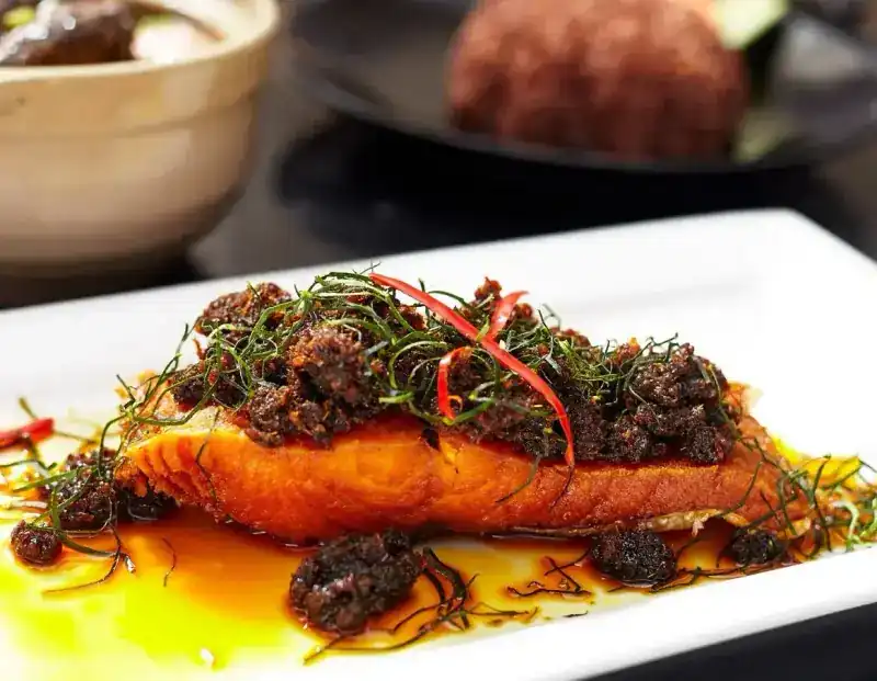 Crisp fried salmon topped with dark southern curry paste, shredded lime leaf and red chilli