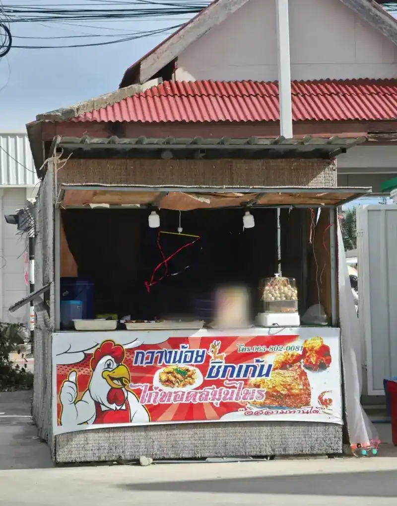 The stall: a small kiosk under a red roof, with a red banner showing a rooster, the name and the phone number