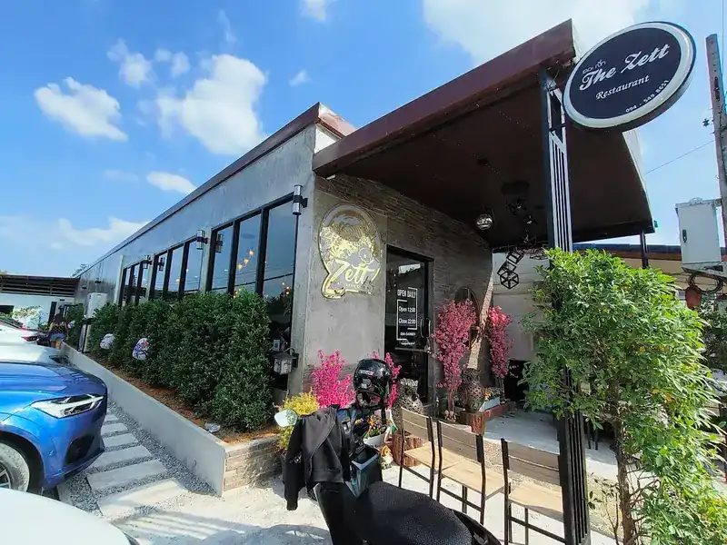 The restaurant from Ban Kay Road: a grey building with a navy oval sign and a gold fish emblem beside the door