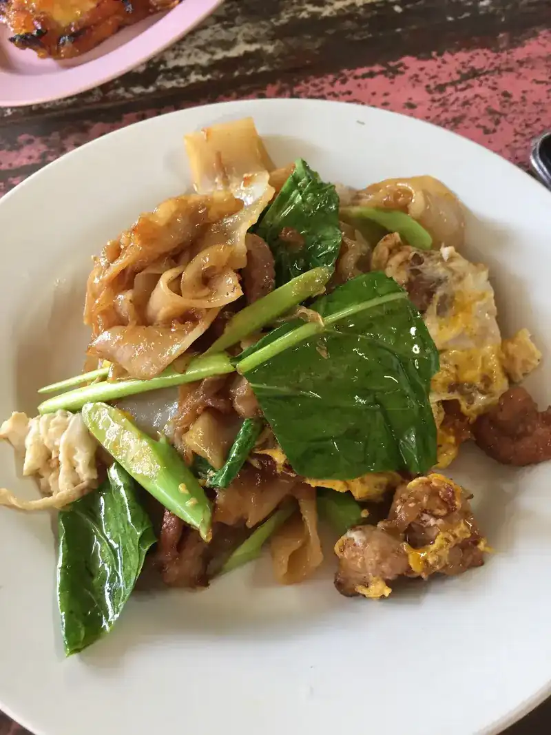 Wide rice noodles fried with pork, egg and Chinese kale