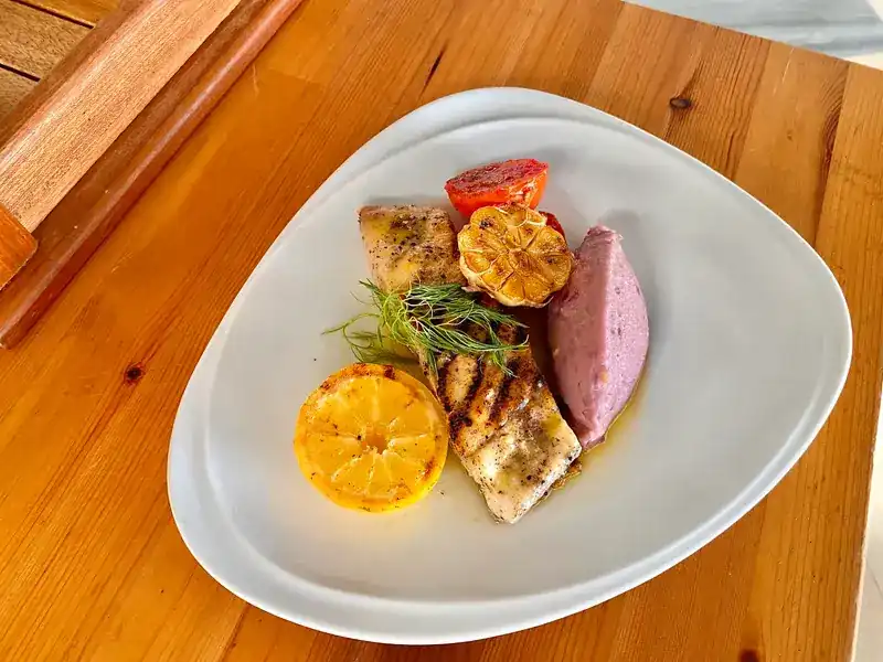 Grilled fish with roasted garlic, lemon and a purple mash