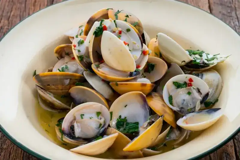 A bowl of clams with garlic, chili and parsley