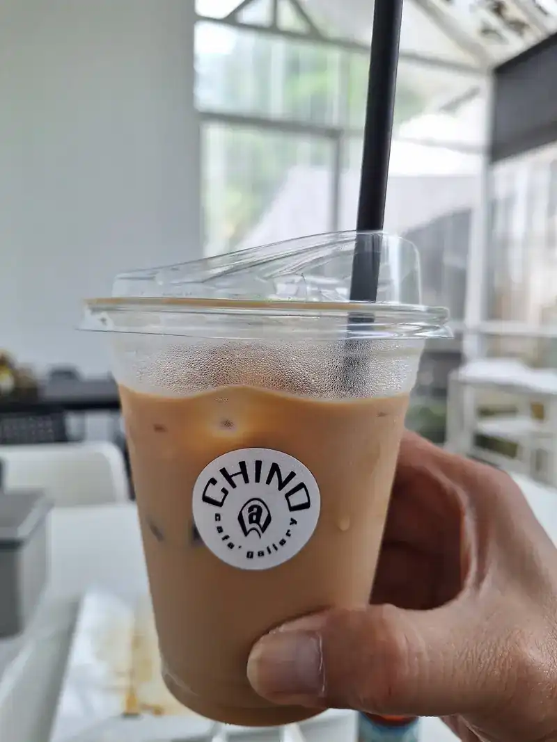 An iced coffee in a cup printed with the Chino mark