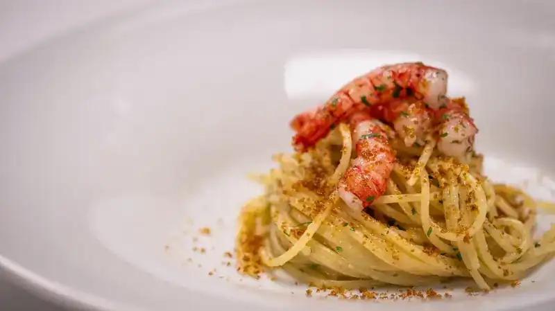 Spaghetti topped with red prawns and toasted crumbs