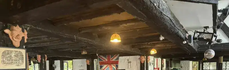 Blackened oak ceiling beams, carved heads on the posts and the Union Jack