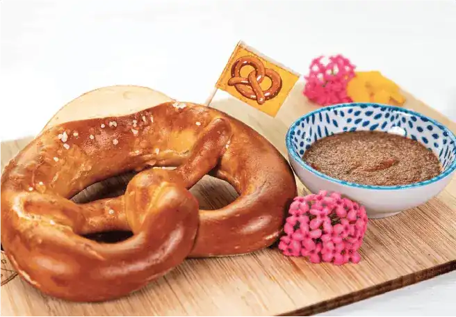 A fresh pretzel with a bowl of sweet mustard