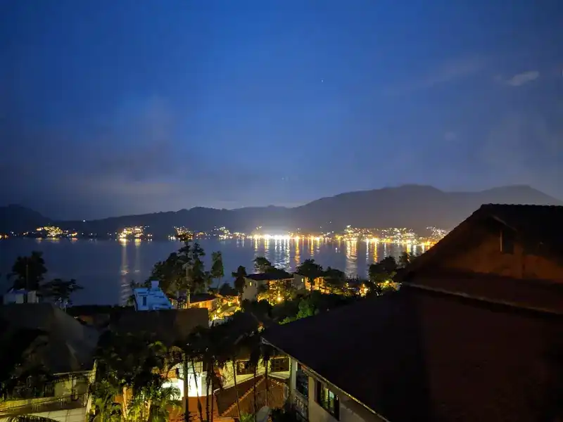 Patong Bay at night, the lights of the shore reflected in the water