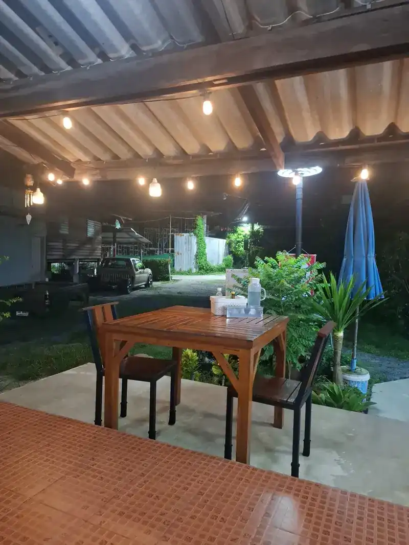 A table out front in the evening under a row of small lights