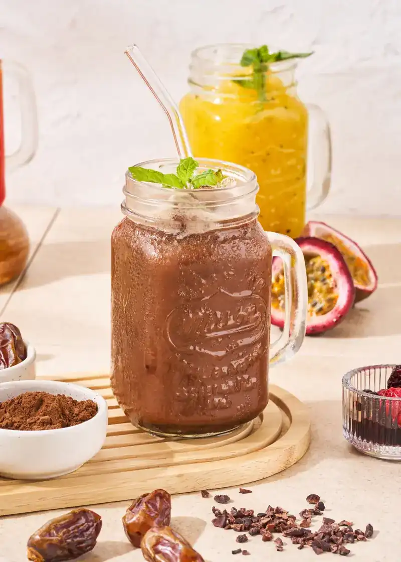 A chocolate smoothie and a passionfruit smoothie in glass jars