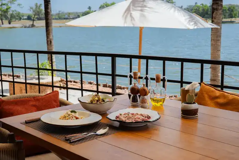 Dishes on a table by the railing, the lake beyond