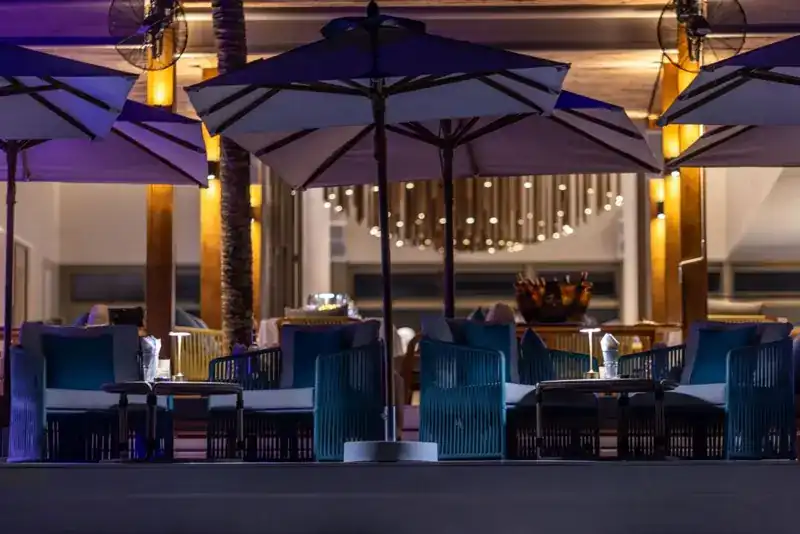Blue lounge chairs under parasols in the evening