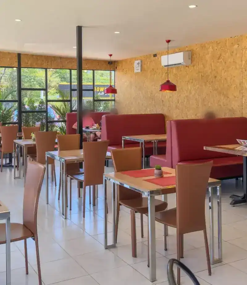 Inside: red booths along a wood-panelled wall, tables and chairs, red pendant lamps and big windows