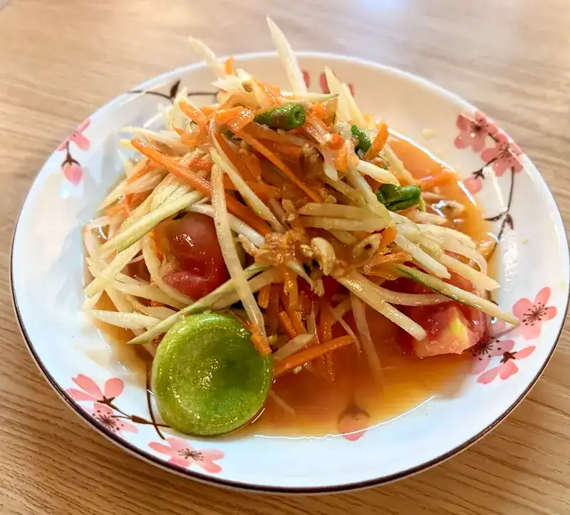 Papaya salad with tomato, carrot and half a lime