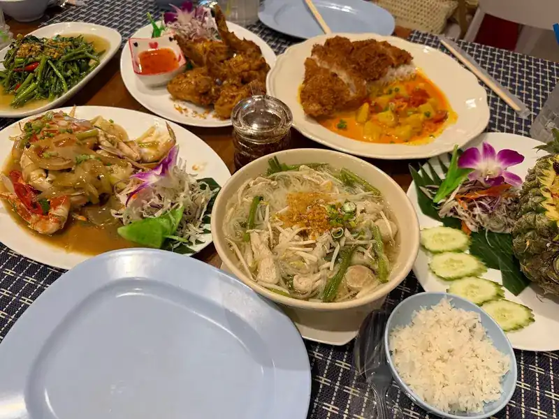 A table of shared dishes with rice / อาหารหลายจานวางแบ่งกันบนโต๊ะพร้อมข้าวสวย
