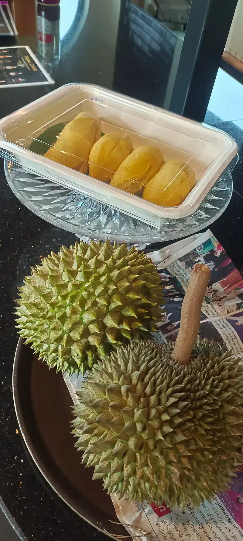 Whole durians beside a box of durian flesh / ทุเรียนทั้งลูก วางข้างกล่องเนื้อทุเรียน
