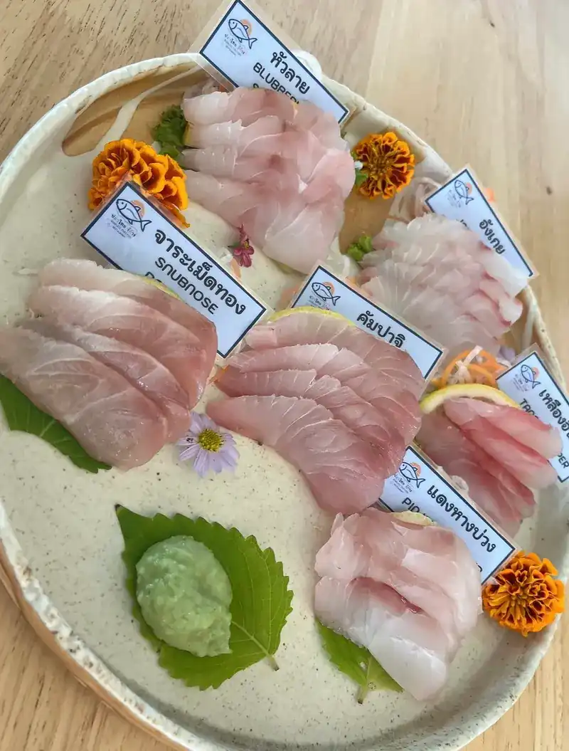 Another sashimi platter: fish laid out with wasabi on a leaf and marigolds
