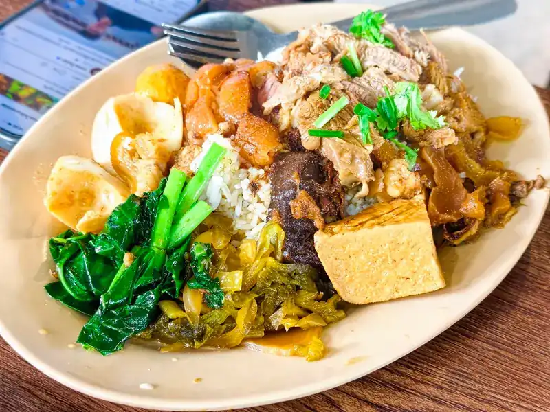 A rice plate with egg, tofu, pork, pickled greens and leafy greens
