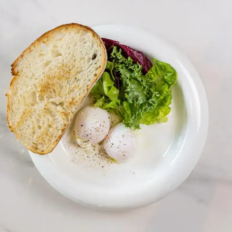 Two poached eggs with salad leaves and toasted bread