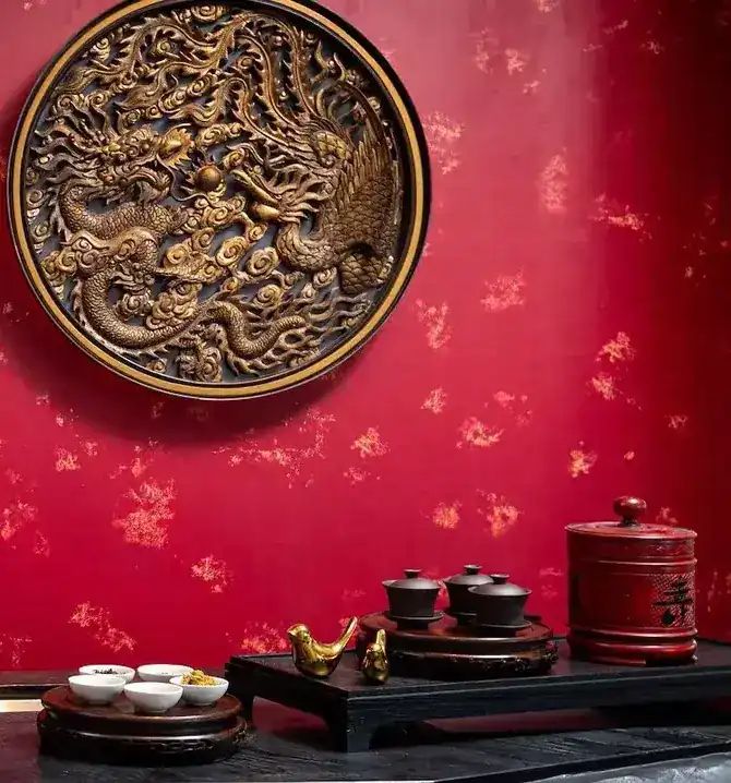 A carved gold dragon medallion on the red wall above the tea counter