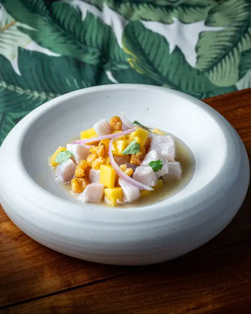Fish ceviche with mango in a white bowl
