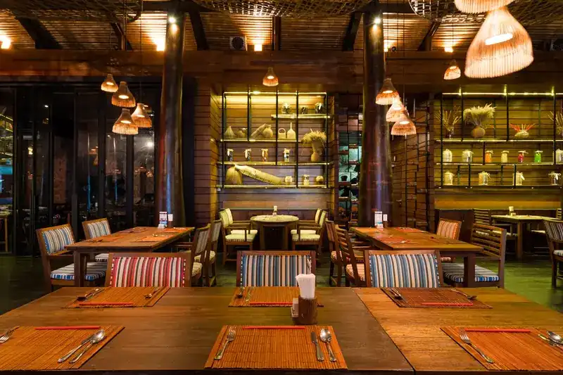 Dining room with woven lanterns, wooden tables and striped chairs