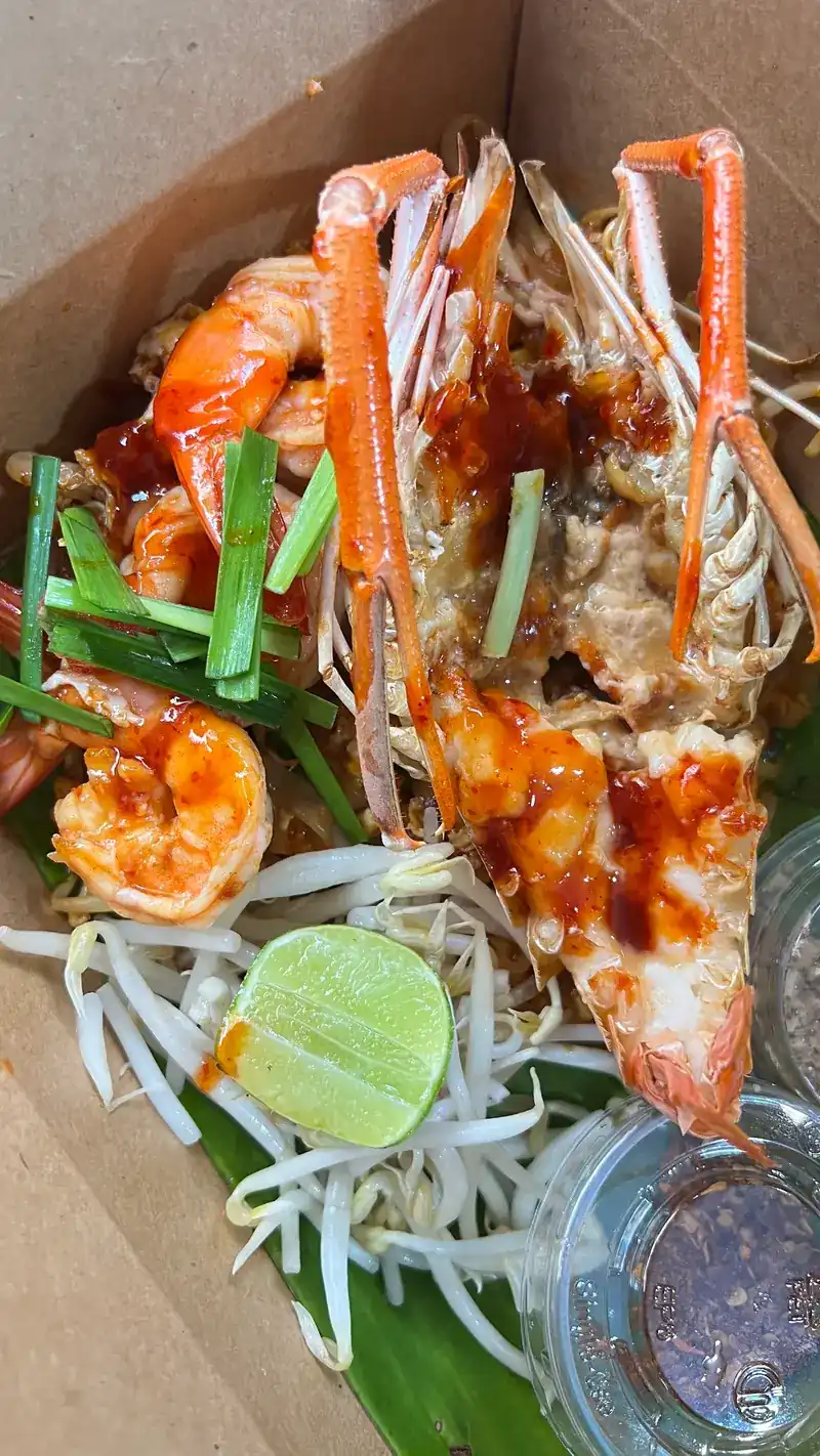 Pad thai with a split river prawn, lime and bean sprouts in a takeaway box