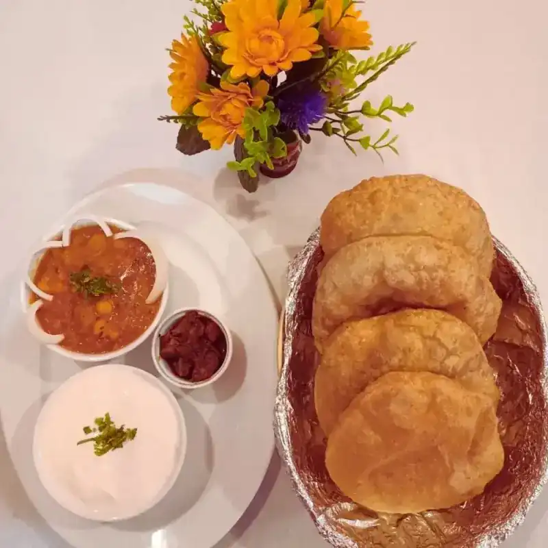 Four puris with chickpea masala, yogurt and pickle