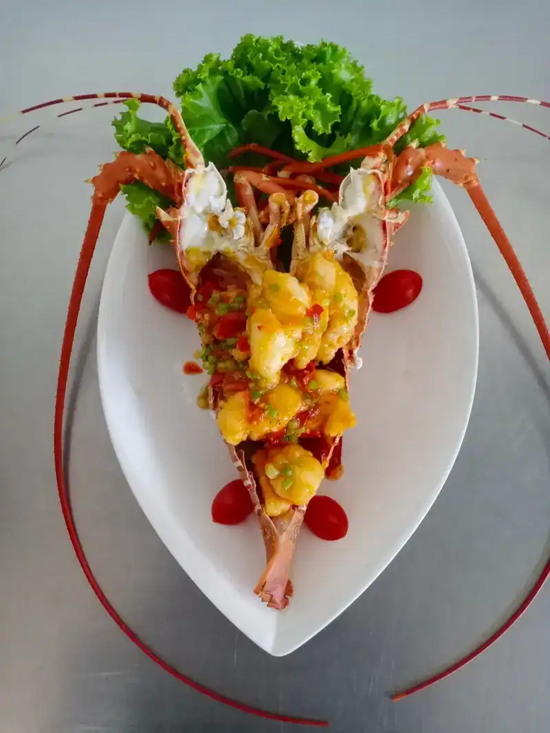 A whole lobster, split and spooned over with sauce