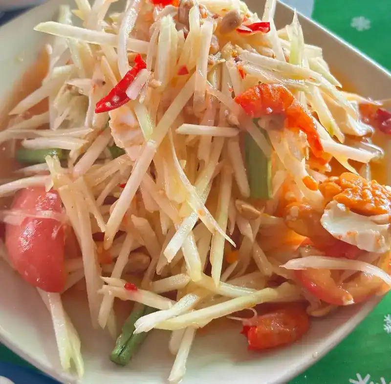 Close-up of papaya salad with tomato, long beans and chilli